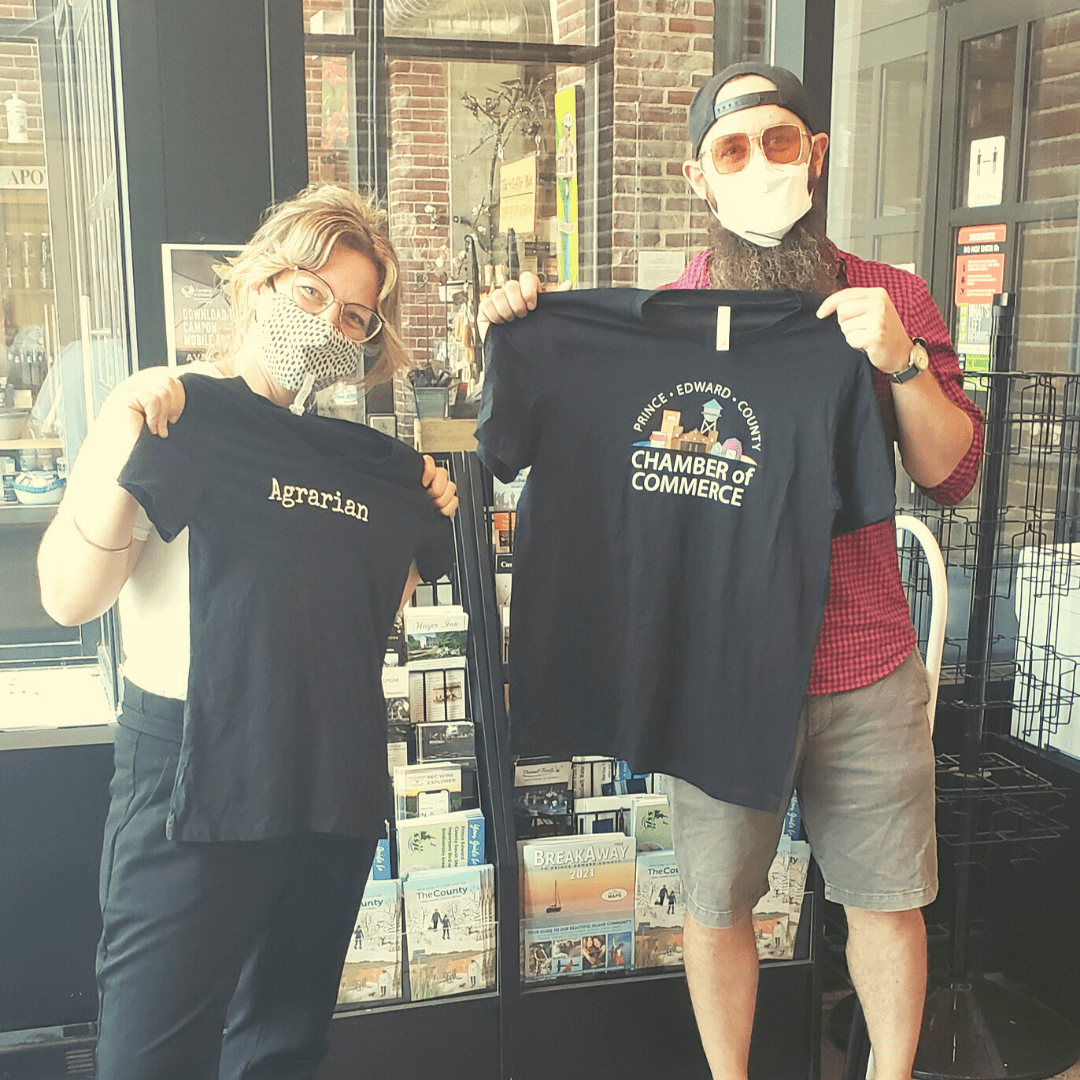 Agrarian Owner and PEC staff member holding up T-shirts they swapped with each other's logos