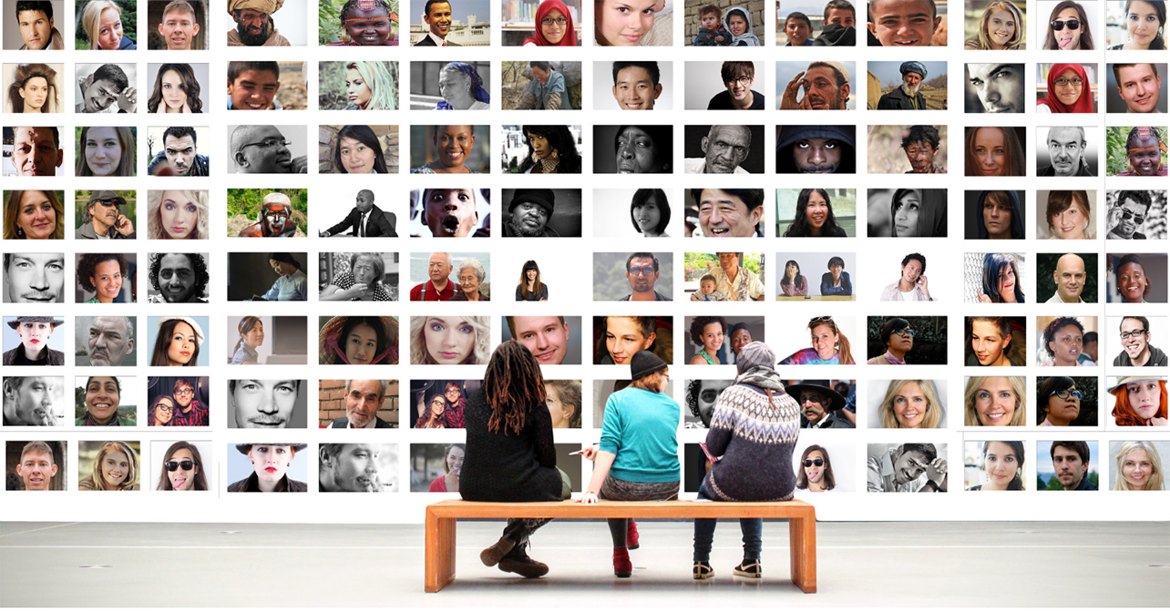 Three people siting on a bench staring at a wall to wall split screen images of other people